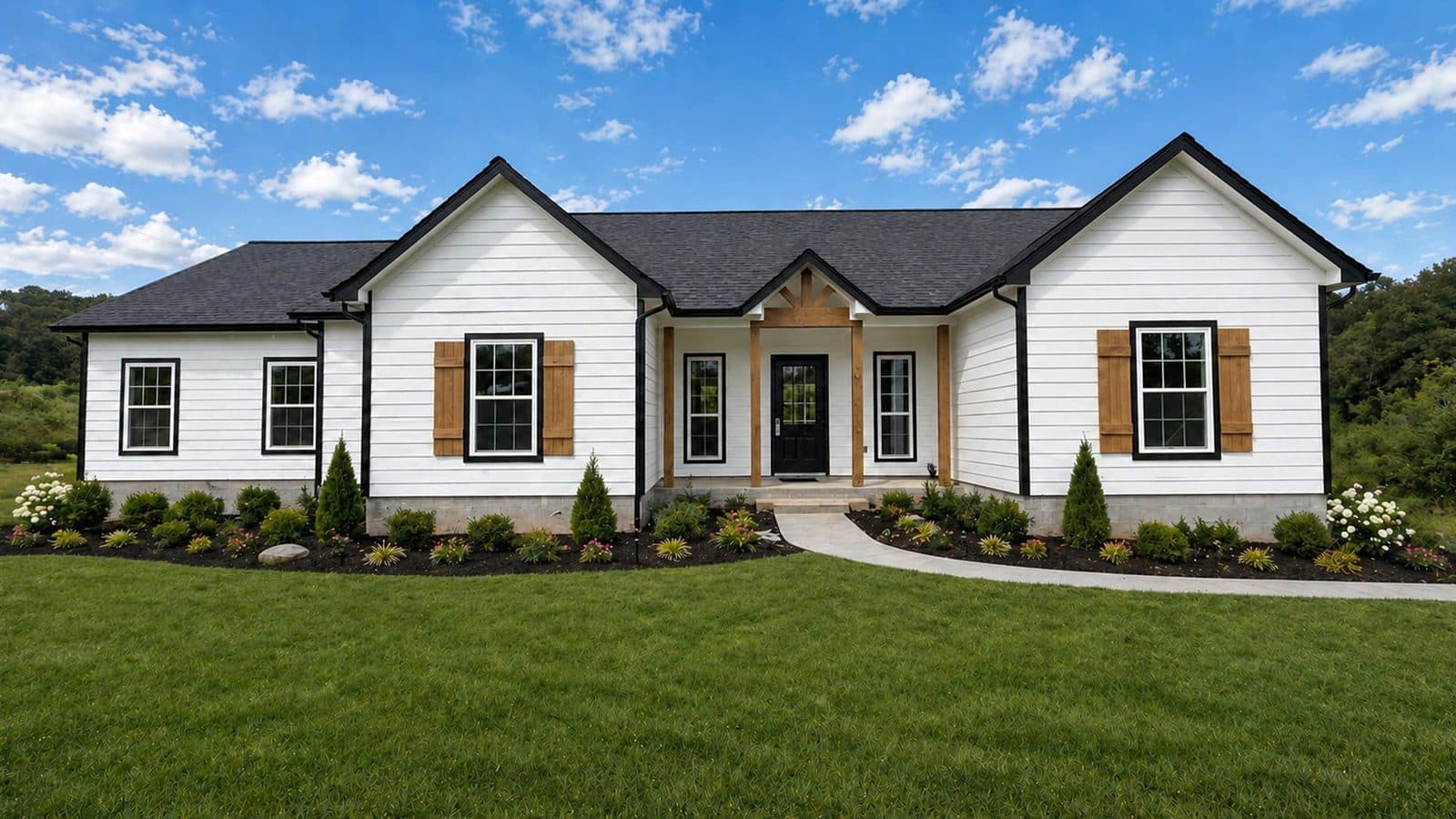 White modern farmhouse with wood shutters and a wide lawn