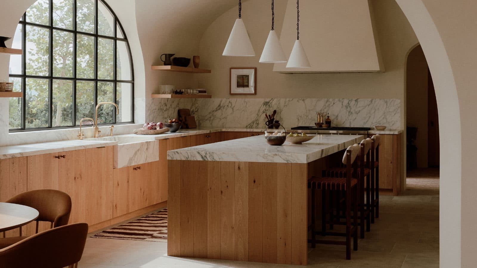 Bright kitchen with a marble backsplash and arched window