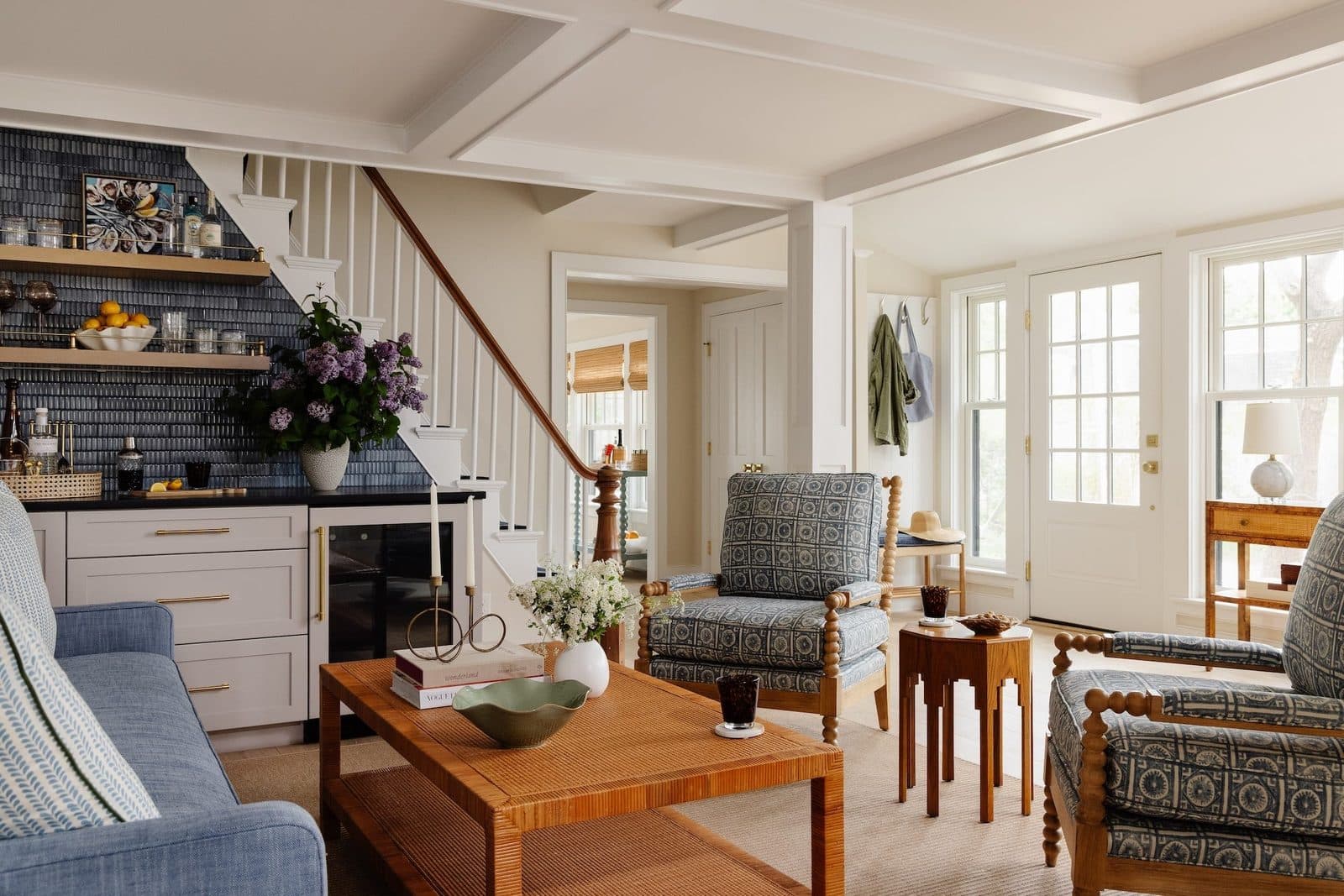 Staged living room with soft blue sofas and coffered ceiling